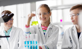 Jugendliche experimentieren im Chemie-Unterricht mit Flüssigkeiten