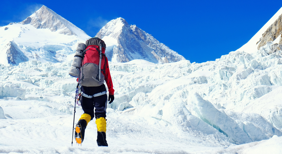 Bergsteigerin vor imposanter Kulisse im Himalaya