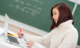 Eine Schülerin sitzt im Mathematikunterricht an ihrem Laptop