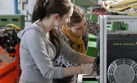 zwei Junge Frauen arbeiten an einem elektronischen Gerät