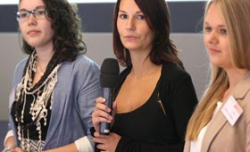 Sina Dobelmann mit zwei weiteren Teilnehmerinnen am Niedersachsen-Technikum. Sina Dobelmann steht in der Mitte mit Mikrofon.