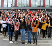 Studierende an der Universität Paderborn winken für ein Gruppenbild